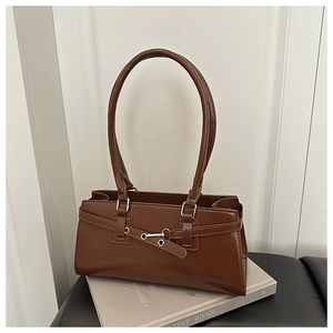 Détail du sac cabas vintage marron foncé en similicuir avec boucle décorative sur livres