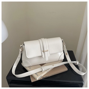 Detail of cream white faux leather shoulder bag with gold clasp and adjustable strap