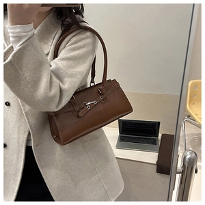 Détail du sac baguette vintage marron foncé en cuir brillant avec boucle en métal argenté