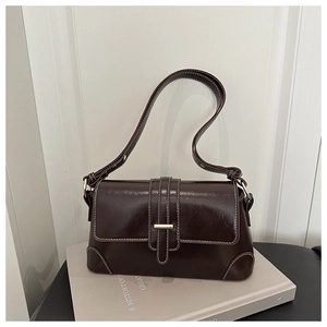 Detail of vintage dark brown faux leather shoulder bag with white stitching and gold buckle