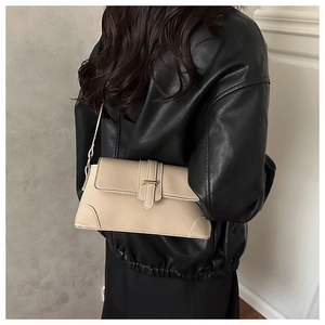 Detailed view of a beige PU leather shoulder bag on a black leather jacket