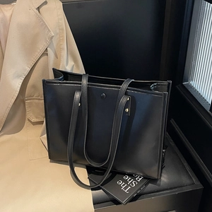 Classic large black tote bag for women with gold rivets and minimalist office style