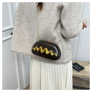 Detail of dark brown leather clutch bag featuring wave gold metal trim and chain strap