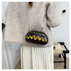 Detaillierte Seitenansicht der dunkelbraunen Abendtasche mit goldener Kette und Wellenmuster