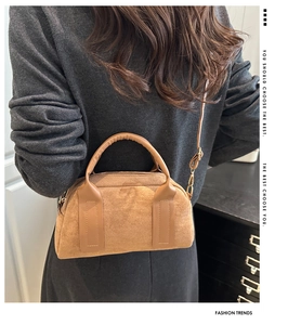 Borsa Boston in pelle scamosciata marrone con tracolla indossata da una modella