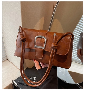 Detail of vintage brown leather bag featuring silver square buckle and knotted strap design