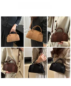 Tre colori di borsa Boston in camoscio indossata come borsa a mano e tracolla su modella