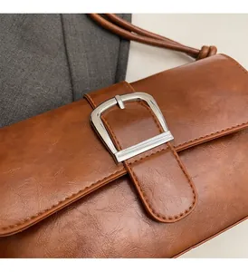 Detailed shot of textured brown leather bag with large silver metal buckle hardware