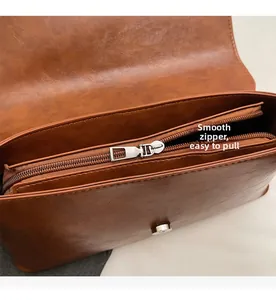 Detail of vintage brown baguette bag featuring smooth silver zipper and magnetic closure