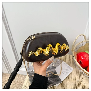Detailaufnahme der dunkelbraunen Muscheltasche mit goldenem Wellendekor und Kette