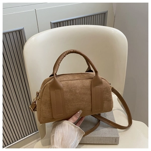 Dettaglio borsa Boston in camoscio marrone con manici in pelle liscia e finiture dorate