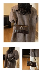 Detail of dark brown glossy leather shoulder bag with silver buckle and knotted strap