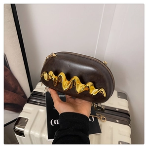 Detailansicht der dunkelbraunen Lederkupplung mit goldener Wellenmetall-Hardware und Kette