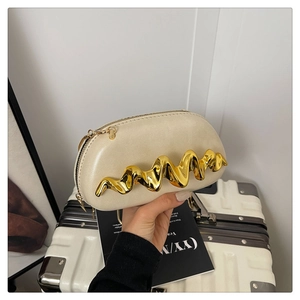 Detail der cremefarbenen halbrunden Handtasche mit goldener Metallverzierung und Zipper
