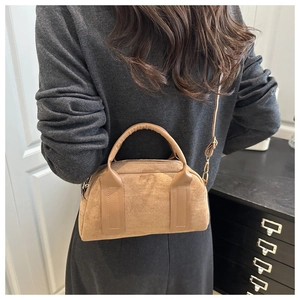 Modello con borsa Boston vintage in pelle scamosciata color cammello e tracolla