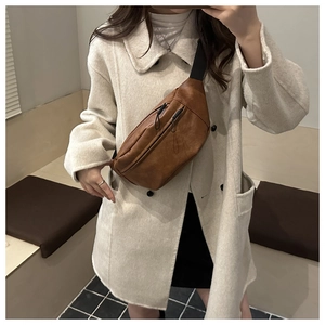 Brown vintage PU leather chest bag with double zippers shown on a white coat