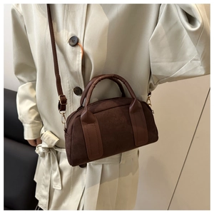 Dettaglio della borsa Boston in pelle scamosciata marrone scuro con tracolla e texture