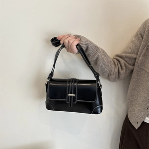 Minimalist black rectangular shoulder bag with white contrast stitching and silver metal buckle