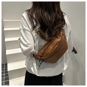 Close-up of brown PU leather crossbody bag showing premium texture and zipper details