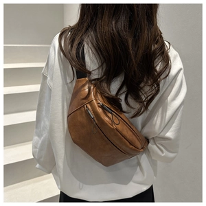 Detail of retro brown PU leather crossbody bag with textured finish and zipper pocket