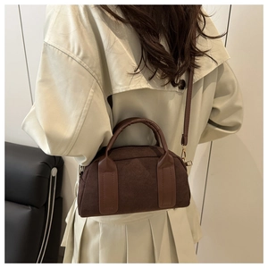 Dettaglio borsa Boston in camoscio testa di moro indossata sopra un trench coat