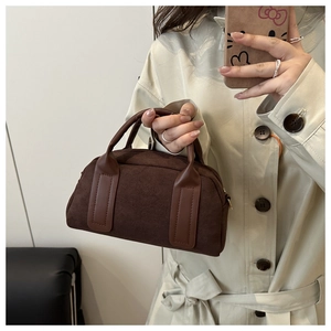 Dettaglio ravvicinato di una borsa Boston in camoscio testa di moro con manici in pelle