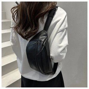 Detail of a matte black saddle chest bag with adjustable strap shown from the back