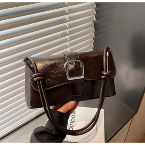 Macro detail of dark brown glossy patent leather bag with vintage silver metal buckle