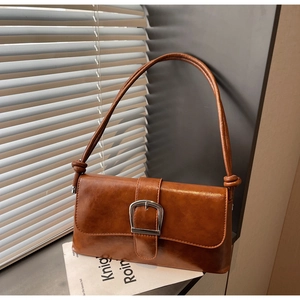 Detail of vintage brown baguette bag featuring silver metal buckle and knotted strap