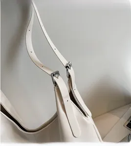 Detail of adjustable shoulder strap with silver buckle on beige minimalist tote bag