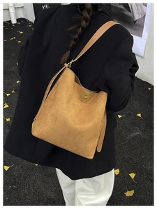Detail of caramel corduroy tote bag featuring a gold metal twist lock and autumn aesthetic