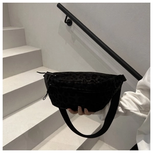 Detail of black leopard jacquard chest bag with dual zippers and woven shoulder strap