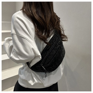 Detailed view of black leopard print crossbody bag with crescent shape and metal zipper