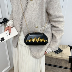 Elegant black crossbody bag with gold wave metal trim and chain strap shown on model