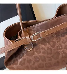Close-up of leopard pattern jacquard fabric and silver metal buckle on tote bag