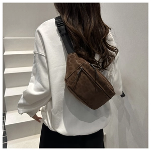 Detail of leopard print chest bag with adjustable black strap on minimalist white stairs