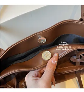 Detail of the strong magnetic buckle and premium leather texture on a shoulder bag