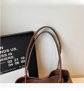 Detail of slim leather handles and smooth suede texture on a brown leopard tote bag