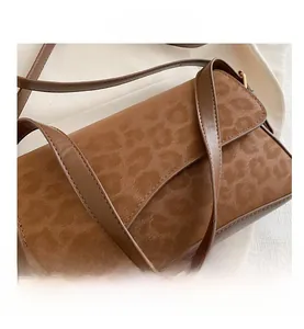 Close-up of leopard embossed texture on vintage brown matte shoulder bag detail