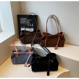 Group display of leopard print tote bags in four colors on minimalist white steps