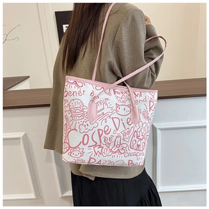 Detail of white canvas tote bag featuring pink graffiti art and slender shoulder strap