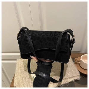 Detail of black crossbody bag featuring leopard print flap and matte suede texture