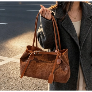 Close-up of leopard print tote bag texture and leather strap in sunset lighting
