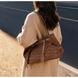 Brown leopard print tote bag styled with a wool coat in a warm outdoor setting