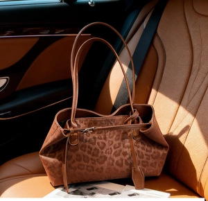 Macro shot of leopard print tote bag with leather straps on a car seat interior