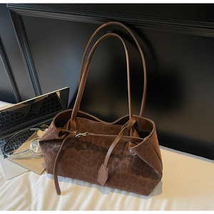 Detailed view of brown leopard print tote bag with adjustable straps in a lifestyle setting