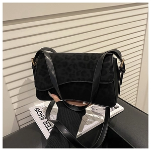 Detailed shot of a black matte crossbody bag featuring a leopard print texture flap