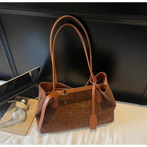 Macro view of leopard print tote bag with metal buckle detail and soft texture