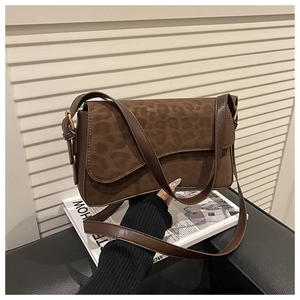 Detail of vintage crossbody bag with leopard print flap and dark brown leather strap