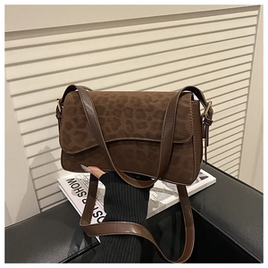 Detail shot of brown crossbody bag with animal print leopard flap and smooth leather strap
